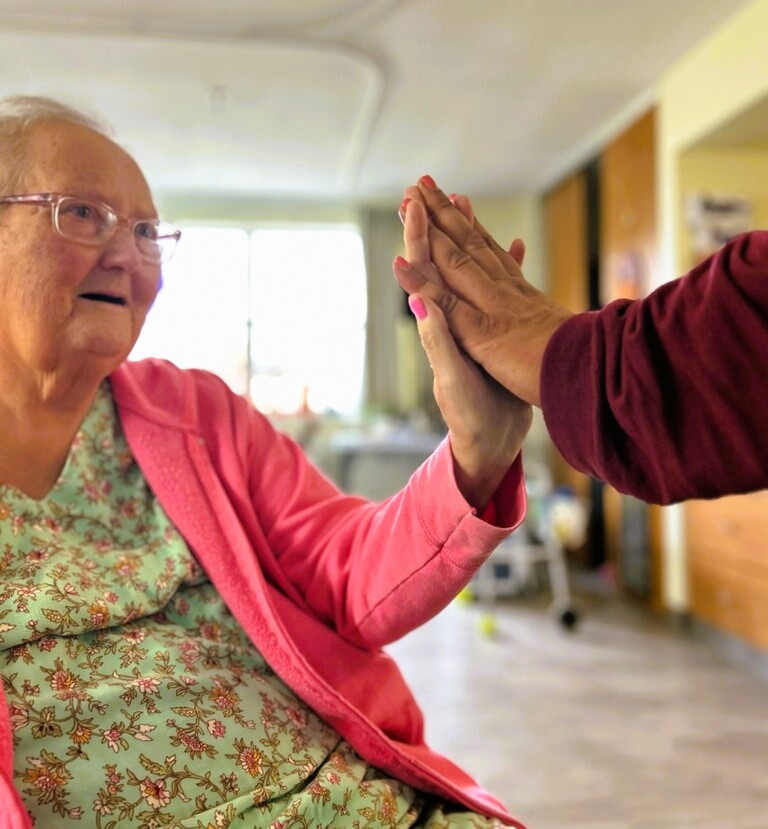 Dianne Merridith high fiving a Nursing Home employee
